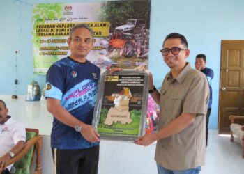 WAN Aminordin Wan Kamaruddin (kiri) menyerahkan cenderamata kepada Ahli Dewan Undangan Negeri (ADUN) Nenggiri, Mohd. Azmawi Fikri Abdul Ghani selepas merasmikan Program 4Xplore Teroka Alam di Pos Pulat, Gua Musang, Kelantan. – UTUSAN/AIMUNI TUAN LAH