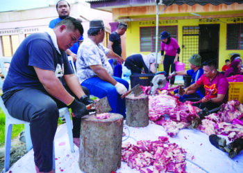 Mangsa tragedi kebakaran paip gas melapah daging korban sempena Hari Raya Aidiladha anjuran Pertubuhan Kebajikan Penduduk Kampung Sungai Baru, di Puchong, semalam. – UTUSAN/SADDAM YUSOFF