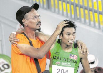 Mohd Poad Md Kassim (kiri) ketika membimbing pelari pecut negara, Khairul Hafiz Jantan pada Kejohanan Terbuka Malaysia. - UTUSAN