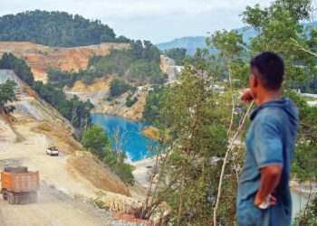 SEORANG penduduk menunjukkan air tasik berwarna biru yang menjadi tumpuan pelancong tempatan di Bukit Ibam, Rompin, Pahang.