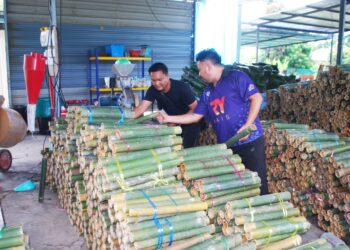 FUAD Hasan (dua dari kanan) memilih buluh daripada seorang pembekal di Malim, Melaka. - UTUSAN/AMRAN MULUP