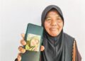 AISAH Abdul Rahim menunjukkan gambar Fatin Nasrien Fadli yang maut dalam kemalangan   di Jalan Raya Timur-Barat (JRTB) berhampiran Tasik Banding, Gerik, Perak. – UTUSAN/WAN ZURATIKAH IFFAH WAN ZULKIFLI