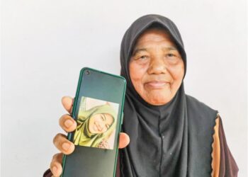 AISAH Abdul Rahim menunjukkan gambar Fatin Nasrien Fadli yang maut dalam kemalangan   di Jalan Raya Timur-Barat (JRTB) berhampiran Tasik Banding, Gerik, Perak. – UTUSAN/WAN ZURATIKAH IFFAH WAN ZULKIFLI