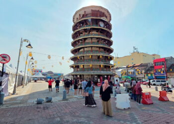KUMPULAN pelancong dari Singapura merakamkan kenangan di Menara Condong, Teluk Intan, Perak. – UTUSAN/AIN SAFRE BIDIN