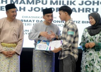 ONN Hafiz Ghazi, diiringi Jafni Md Syukor, menyampaikan sijil pemilikan rumah kepada seorang pembeli sempena Majlis Mega J-Home One Stop Centre (OSC) dan Penyerahan Sijil (SLMR) Rumah Mampu Milik Johor Daerah Johor Bahru di Dewanraya Taman Bukit Indah, Iskandar Puteri. - UTUSAN/RAJA JAAFAR ALI