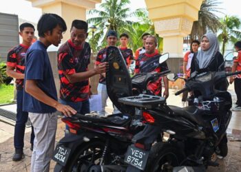 SAIFUL Azri Rosdi melihat motosikal Yamaha LC135 yang dihadiahkannya kepada Muhammad Mustaqim di Masjid Hadhari, Jerteh, Terengganu. - UTUSAN/PUQTRA HAIRRY