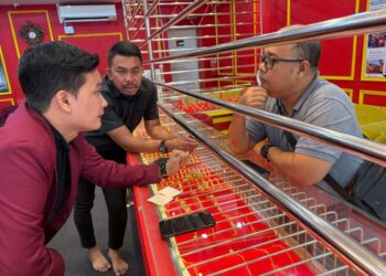 PEKERJA Mz Gold Sdn. Bhd melayan pelanggan yang berkunjung ke premis mereka untuk melihat barang kemas di Kota Bharu, Kelantan, semalam.