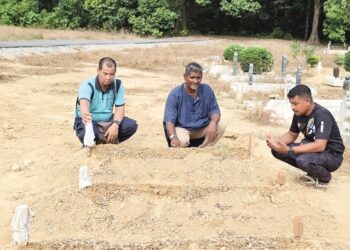 AZIZ Jaafar Yusof (tengah) menziarahi kubur anak dan menantunya di Kampung Selat, Bota Kanan dekat Parit, Perak, semalam. – UTUSAN/AIN SAFRE BIDIN