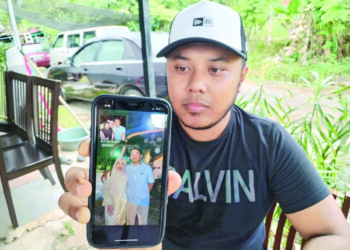 IZWAN Iskandar Che Sopian menunjukkan gambar swafoto terakhir Fakrul Arif Rosdi bersama keluarga sebelum maut ketika ditemui di Kampung Pasir Akar, Besut, Terengganu.