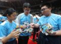 ETHAN Ling (tengah) bersama Abrielle Siow (kiri) dan seorang lagi peserta yang menyertai Pertandingan Robot Belia Antarabangsa (IYRC) ASEAN 2025 di Kompleks Sukan EduCity, Iskandar Puteri menunjukkan robot masing-masing.
