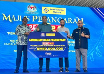 Ahli Lembaga Pemegang Amanah (AIM), Mohd Najib Mohd Noor (kanan) menyerahkan mock check tambahan dana pembiayaan peruntukan P.E.N.N sebanyak RM50 juta kepada Datuk Seri Ramanan Ramakrishnan. UTUSAN/NURUL NATASHA SURIN