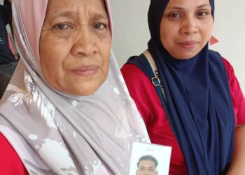 NASRAH Ahmad menunjukkan gambar anaknya, Muhammad Irwan Syah Yahaya yang meninggal dunia dalam kemalangan di Jalan Parit Panjang, Kampung Padang Tembak di Baling.