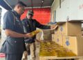 S. JEGAN (kanan) memeriksa minyak peket bersubsidi yang dirampas di gudang kurier di Sungai Puyu, Butterworth, Pulau Pinang