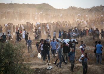 RIBUAN penduduk Palestin bertempiaran mengelak serangan tentera Israel ketika mengangkut bantuan dari pusat agihan di tengah Semenanjung Gaza. - AFP