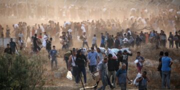 RIBUAN penduduk Palestin bertempiaran mengelak serangan tentera Israel ketika mengangkut bantuan dari pusat agihan di tengah Semenanjung Gaza. - AFP