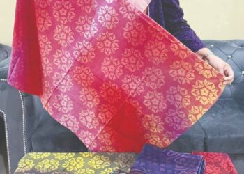 NOAZAH Ahmad Tahir menunjukkan produk Batik Perak yang dihasilkannya di Pasir Salak. –  UTUSAN