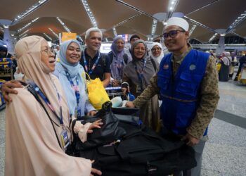 MOHAMAD Taha Hassan (kanan) menyantuni para jemaah umrah Andalusia bagi musim 1447H Hijrah ke Tanah Suci di KLIA. - UTUSAN/FAISOL MUSTAFA