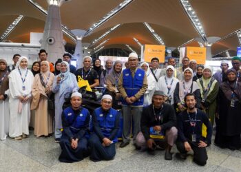 MOHAMAD Taha Hassan (tengah) bergambar dengan para jemaah ketika pelepasan kumpulan pertama  jemaah umrah Andalusia bagi musim 1447H Hijrah ke Tanah Suci di KLIA Terminal 1. - UTUSAN/FAISOL MUSTAFA