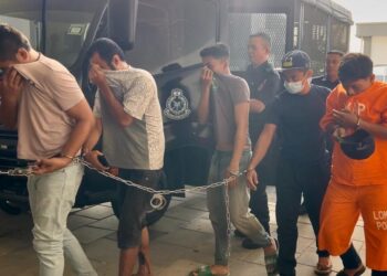 TERTUDUH (dua dari kanan) dibawa ke mahkamah bagi berdepan pertuduhan mengedar dadah berbahaya jenis syabu pada bulan lalu 
di Kompleks Mahkamah Kangar, Perlis, semalam.  UTUSANASYRAF 
MUHAMMAD