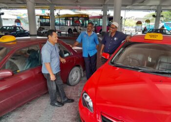 BAHARUDDIN Abu Bakar (kanan) bersama Abd. Ghani Abd. Samad (kiri) dan M. Ayaboo menunggu kehadiran penumpang di Terminal 
Tun Sri Lanang, Kota Tinggi, Johor.
