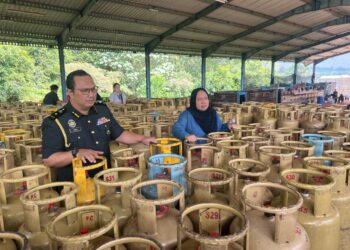 LILIS SASLINDA Pornomo melihat tong LPG yang dirampas di sebuah stor menyimpan buah kelapa sawit di Jalan Johor Bahru-Ayer Hitam di Machap, Kluang.