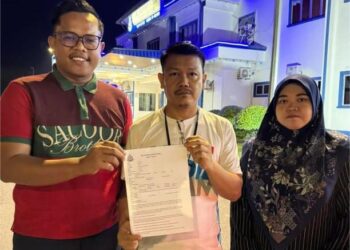 HANIFF@ Ghazali Hosman ( tengah ) menunjukkan laporan Polis yang oleh PKR Cabang Pontian di Balai Polis Pontian, di Pontian, malam tadi.