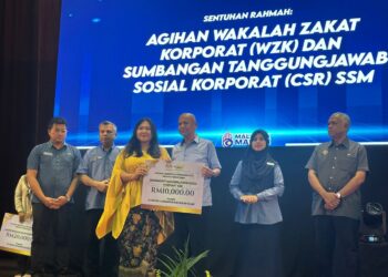 Armizan Mohd. Ali  (tiga dari kanan) menyerahkan sumbangan tanggungjawab sosial korporat SSM kepada seorang penerima pada majlis Program Pendigitalan Perniagaan 2025 (PPP25) di Kota Kinabalu, Sabah, kelmarin.
