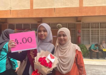 Alyaa (kiri) ditemani ibunya ketika hadir untuk mengambil keputusan STPM di Kolej Tingkatan Enam Haji Zainul Abidin, George Town, Pulau Pinang.