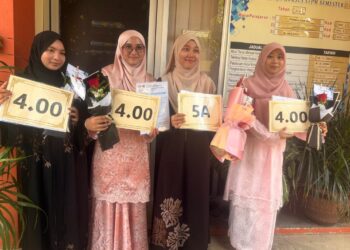 TENGKU Nurhanis Tengku Othman (dua dari kiri) bersama tiga rakannya yang turut cemerlang dengan mendapat keputusan PNGK 4.0 dalam STPM di SMKA Naim Lilbanat Kota Bharu, Kelantan hari ini.-UTUSAN/ROSLIZA MOHAMED.