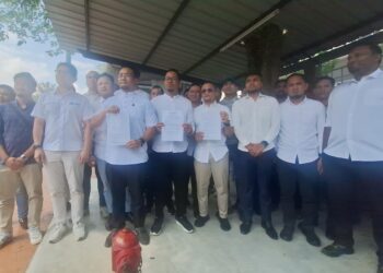 MUHAMMAD IZUAN Ahmad Kasim (tengah) menunjukkan laporan polis berhubung isu itu di perkarangan luar IPD Shah Alam, Selangor hari ini. -UTUSAN/ISKANDAR SHAH MOHAMED