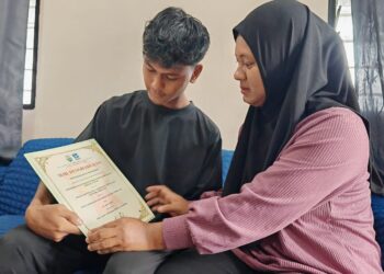 MUHD. Alif Najmi Muhd. Nor Faizal dan Amizaliana Baharom melihat sijil kecemerlangan STPM 2024 yang diperolehnya di Felda Tersang 2, Raub, Pahang.