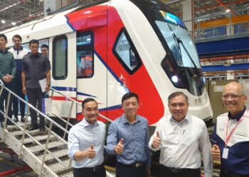 ANTHONY Loke Siew Fook (dua dari kanan) bersama Jeffrey Siow (tiga kanan) serta Onn Hafiz Ghazi (kiri) bergambar di hadapan tren pertama RTS Link di Pusat Ujian Rel Singapura (SRTC), Tuas, Singapura.