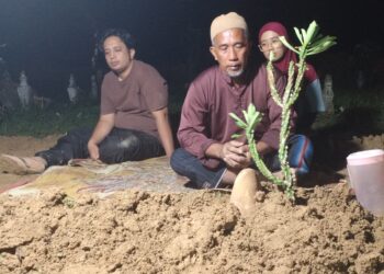 AHLI keluarga Muhammad Adib Azim Halim berada di pusara Allahyarham selepas selesai majlis pengebumian di Tanah Perkuburan Islam Kampung Pasir Badak, Besut, Terengganu. - UTUSAN/WAN ZURATIKAH IFFAH WAN ZULKIFLI