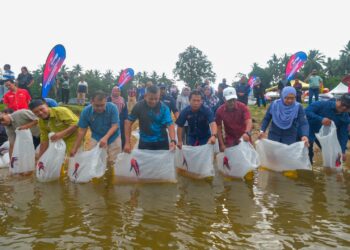 AZMAN Ibrahim (tengah) melepaskan benih anak ikan pada Program Pelepasan Benih Ikan, Penyerahan Bantuan Peralatan dan Insentif Input Akuakultur serta Pelancaran Kajian Penandaan Peralatan Menangkap Ikan Nelayan Darat di Kampung Temir, Kuala Berang, Terengganu.