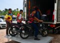 SUKARELAWAN Universiti Pendidikan Sultan Idris (UPSI) menurunkan motosikal milik mangsa kemalangan di Gerik, Perak untuk diserahkan kepada waris mereka  di Masjid Hadhari, Jertih, Besut, Terengganu. - UTUSAN/PUQTRA HAIRRY