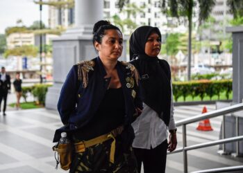 PERSANA Avril (kiri) dibawa ke Kompleks Mahkamah Kuala Lumpur dalam keadaan bergari bagi menghadapi pertuduhan memuat naik sijil nikah palsu dengan Tengku Mahkota Johor.