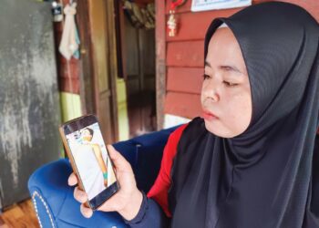 MISS Mayuedah Ishak menunjukkan gambar anak sulungnya yang ditidurkan di HTJS, Seremban sejak Khamis lalu ketika ditemui di Kampung Baru Chengkau Ulu, Rembau semalam. – UTUSAN/NOR AINNA HAMZAH