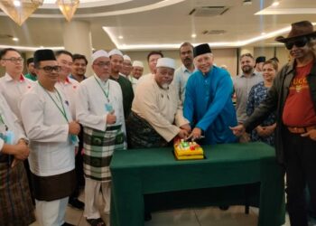 ANNUAR  melakukan gimik memotong pulut kuning ketika merasmikan Mesyuarat Agung Pas Pulai di sini hari ini.
