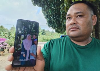 MOHD. Farid Firdaus Azman menunjukkan gambar adiknya yang merupakan salah seorang mangsa yang maut dalam tragedi bas membawa pelajar Universiti Pendidikan Sultan Idris (UPSI) ketika ditemui  di Kampung Gong Pasir, Besut, Terengganu. - UTUSAN / WAN ZURATIKAH IFFAH WAN ZULKIFLI