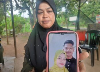 SITI Fatimah Mat Rejab menunjukkan gambar kenangan bersama arwah anak sulungnya, Allahyarham Muhammad Fahmi Jamel ketika ditemui di Kampung Berona Kanan, Jeniang di Sik.