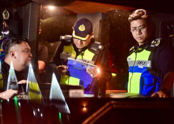 MOHD. Zamri Samion (kanan) semasa melakukan pemeriksaan terhadap pemandu bas menerusi Op Khas Sempena Hari Raya Aidiladha 2025 di Jambatan Sultan Mahmud, Kuala Terengganu, malam tadi. -UTUSAN/PUQTRA HAIRRY