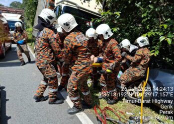 ANGGOTA bomba membantu mangsa kemalangan di Kilometer 58, Jalan Raya Timur-Barat (JRTB) Gerik-Jeli dekat Gerik hari ini. - UTUSAN/IIHSAN JBPM