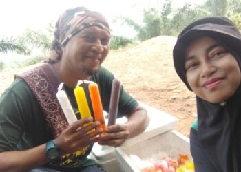 ZASHARINA Zul bersama suaminya menunjukkan aiskrim Malaysia dijual di puncak Bukit Penarikan, Jempol.
