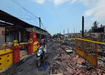 PENDUDUK melihat sisa kebakaran rumah di Bagan Pasir Laut, Hutan Melintang di Bagan Datuk hari ini. -UTUSAN/AIN SAFRE BIDIN