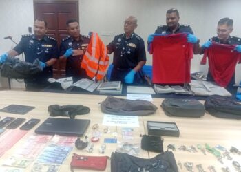 HANYAN Ramlan (tengah) menunjukkan pakaian sebuah syarikat utiliti yang digunakan Geng Jack untuk memecah masuk premis pada sidang akhbar di IPD Kuala Muda, hari ini.