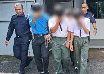 ANGGOTA polis mengiringi sebahagian daripada sembilan pelajar yang ditahan reman di Mahkamah Kemaman, Terengganu. -UTUSAN/NIK NUR IZZATUL HAZWANI NIK ADNAN