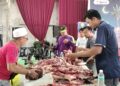 PENDUDUK melapah daging lembu pada program korban perdana Parlimen Bukit Gantang hari ini. - UTUSAN/WAT KAMAL ABAS