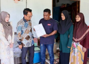 MOHAMAD Nasir Kareem (dua dari kiri) menyerahkan sijil kematian kepada Mohamad Isma Abdul Manaf, (tiga dati kanan), bapa kepada Nur Dalila Farhana, pelajar Universiti Pendidikan Sultan Idris (UPSI) yang maut dalam nahas di Gerik, Perak di Kampung Baru Tok Dor, Jertih, Besut, Terengganu. -UTUSAN/PUQTRA HAIRRY