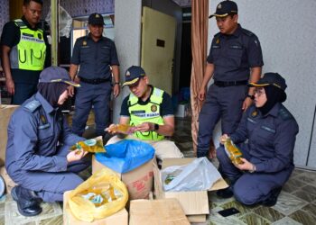 MOHD. Mufsi Lat (tiga, kanan) memeriksa minyak masak paket yang dirampas di sebuah kedai warga asing dalam satu Operasi Bersepadu Agensi Penguatkuasaan di Bukit Payung, Marang, Terengganu. -UTUSAN/PUQTRA HAIRRY