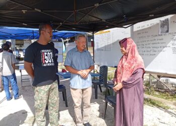 KHAZAN Che Mat  (tengah) memberi kata semangat kepada Faridah Chik (kanan) ketika melawat pusat operasi menyelamat di Jeti Tok Jembal, Kuala Nerus, Terengganu. - UTUSAN/ ERMA YUSNIDA JUSOH